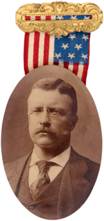 ROOSEVELT 1904 OVAL SEPIA TONED REAL PHOTO BADGE ON BRASS BAR WITH FLAG RIBBON.