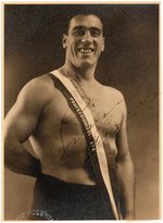 BOXING LEGEND PRIMO CARNERA SIGNED REAL PHOTO POSTCARD.