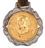 "WOODROW WILSON" BRASS SHELL DISK TABBED TO WHITE METAL WATCH FOB.