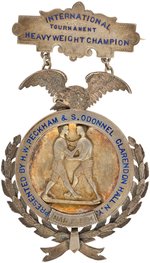 1894 (WRESTLING) "INTERNATIONAL TOURNAMENT HEAVYWEIGHT CHAMPION MAR. 19" SILVER AWARD BADGE.