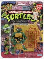 TEENAGE MUTANT NINJA TURTLES (1987) - MICHAELANGELO SPANISH/BANDAI CARDED ACTION FIGURE (SOFT HEAD).