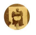 HUGE WOMAN WITH FALLING SKIRT ON BICYCLE CARTOON BUTTON CIRCA 1896.