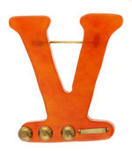 LARGE PLASTIC VICTORY PIN WITH MORSE CODE BRASS ACCENTS.