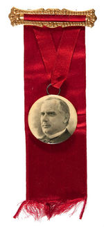 McKINLEY 1896 CELLO AS PENDANT ON RED RIBBON BADGE.