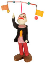 CLOWN WITH WOODEN FEET AND TWIRLING FLAGS WIND-UP.