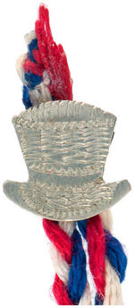 McKINLEY GLASS CUBE ON RWB CORD WITH BENJAMIN HARRISON HAT STICKPIN.