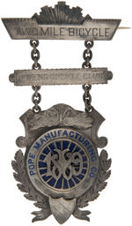 “POPE MANUFACTURING CO./1889/TWO MILE BICYCLE/QUEENS BICYCLING CLUB” AWARD BADGE.