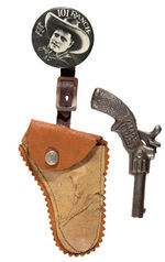 "JACK HOXIE 101 RANCH" RARE BUTTON WITH SUSPENDED HOLSTER AND CAST IRON CAP GUN.