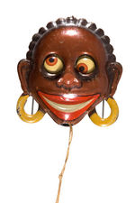 BLACK AFRICAN WITH SPINNING EYEBALLS LITHO TIN MECHANICAL BADGE.