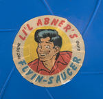 “LI’L ABNER’S SPESHUL BRAND ORANGEADE” JUICE CAN AND “FLYIN’ SAUCER” FRISBEE.